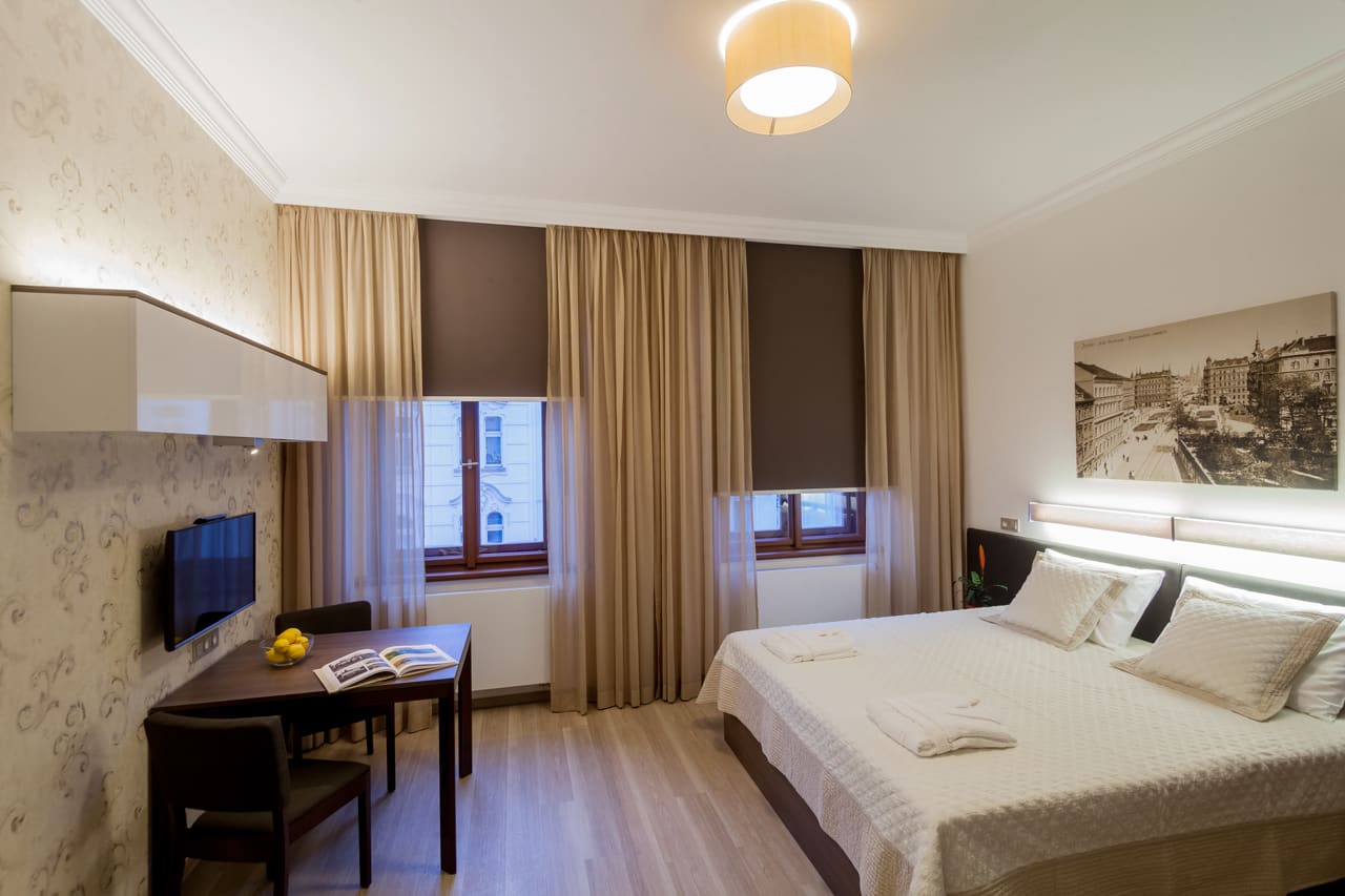 Indulge in a delightful stay at Apartment Hotel Vinohradský Dům in Prague. Our Deluxe Suite features a plush bed, TV, and a functional desk. Reserve your accommodation now!