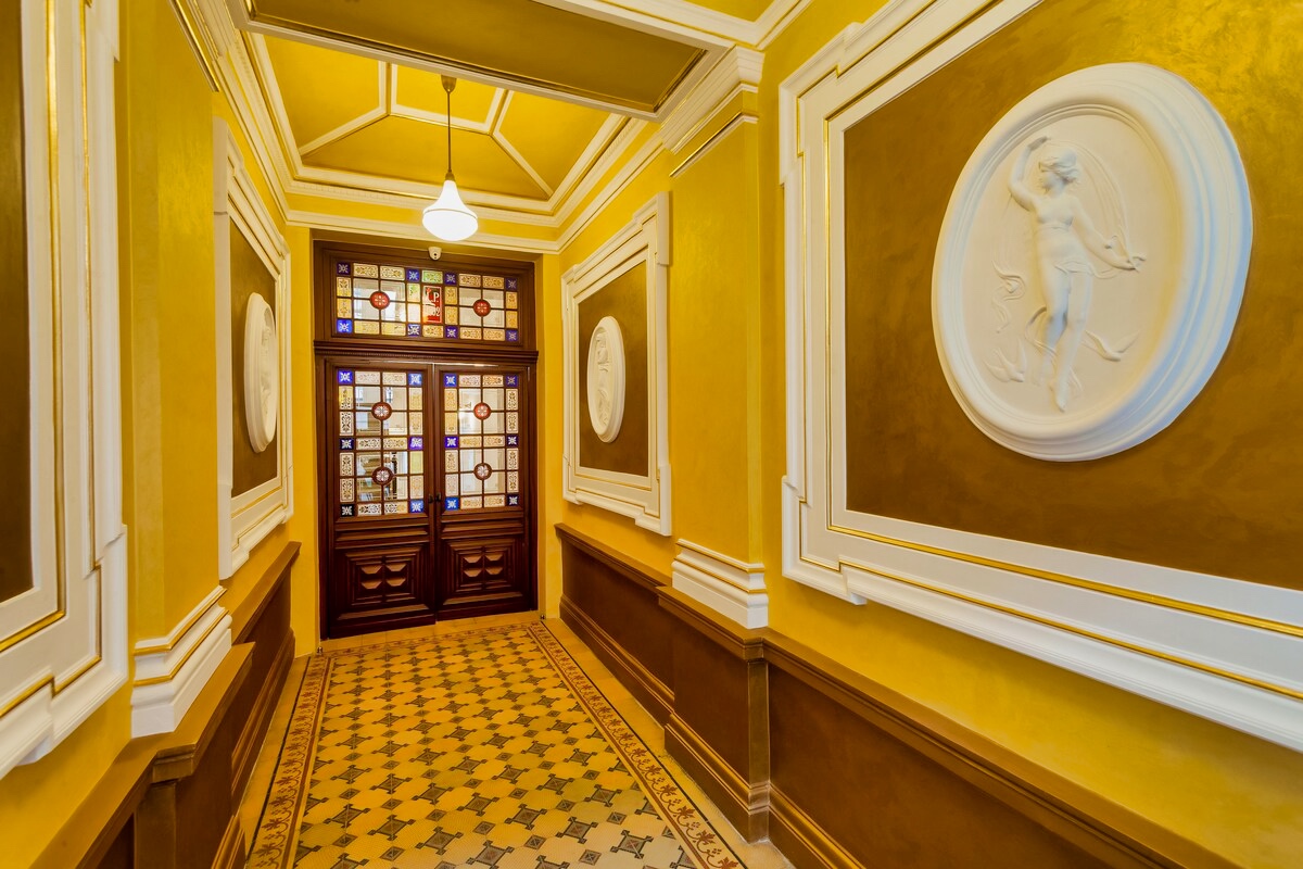 Step into luxury at Aparthotel Vinohradský dům Prague, where a stylish hallway adorned with a white wall and gold trim sets the tone for a memorable stay.