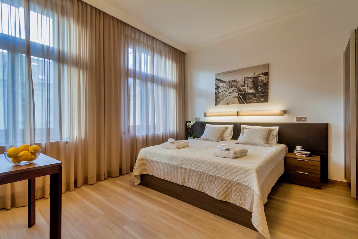Unwind in style at Aparthotel Vinohradský Dům's Studio Superior bedroom with a plush bed and a breathtaking window scene.